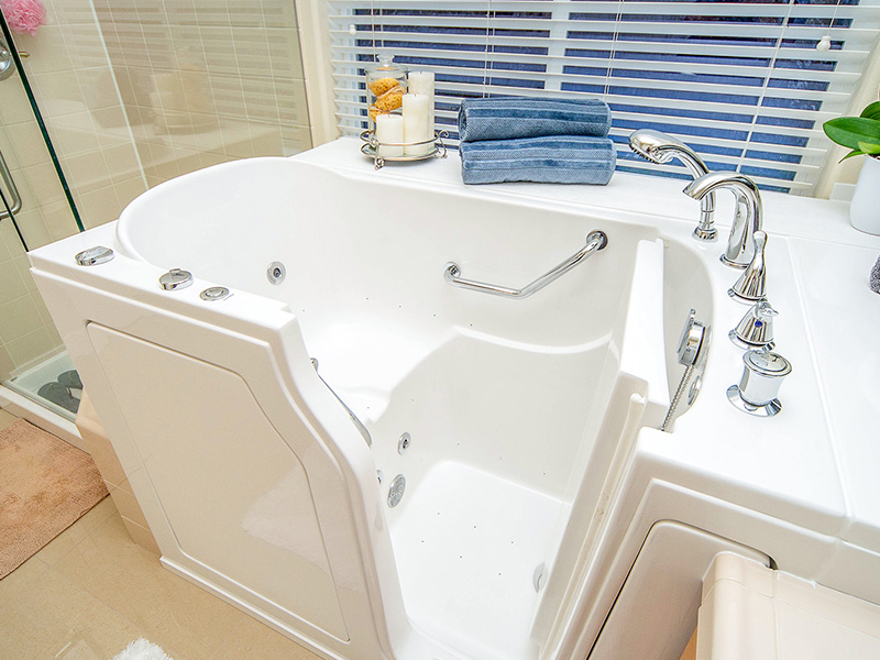 An image of a modern bathtub with a claw foot design, positioned next to a window, and accompanied by a sink and toilet.