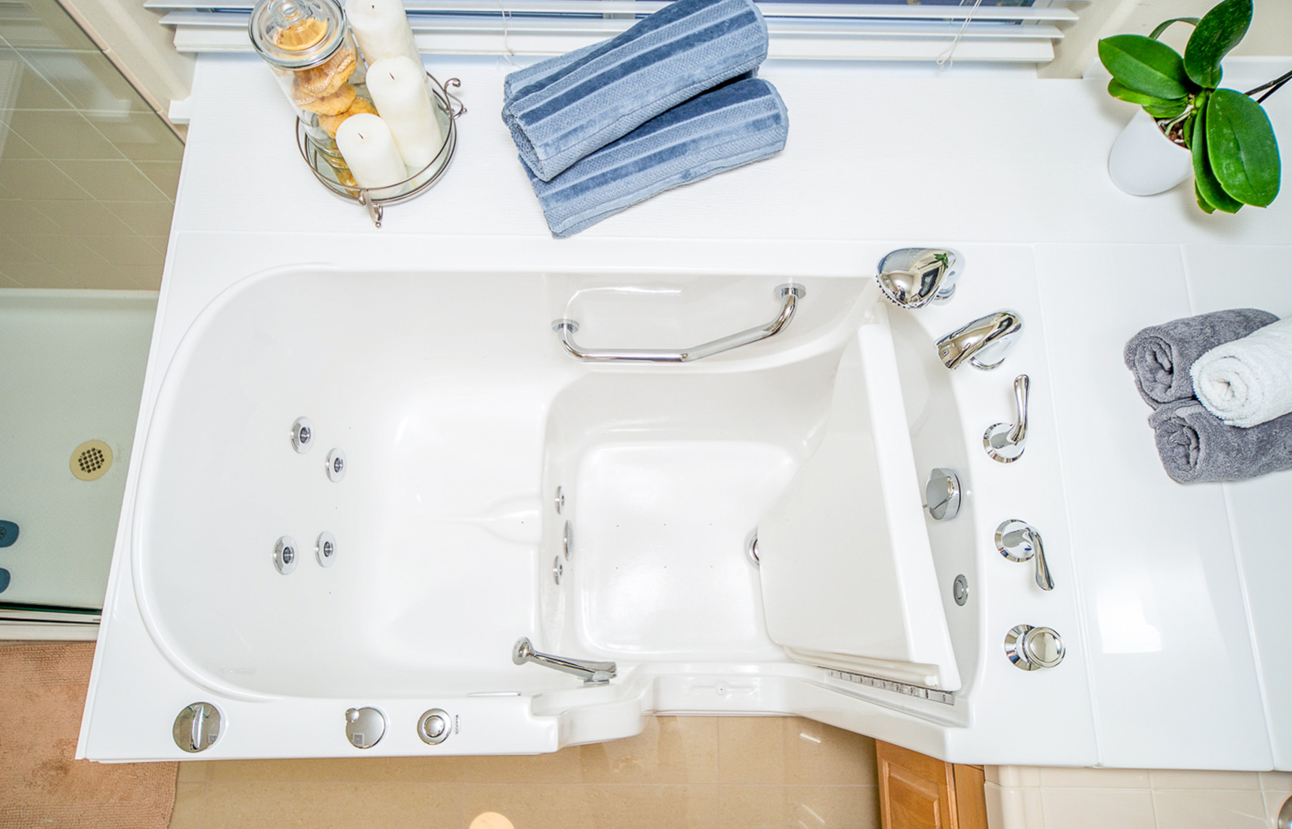The image shows a modern bathroom with a large white bathtub, a built-in seat, and a freestanding sink with a rectangular basin.