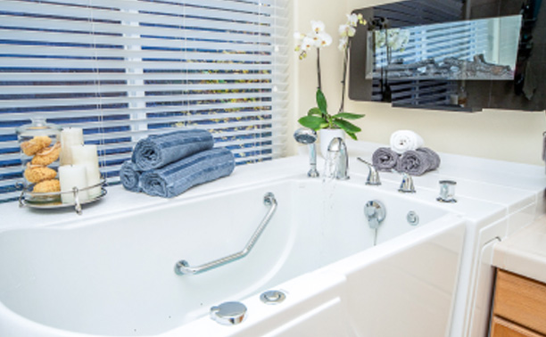 The image shows a modern bathroom interior with a white sink, blue towels, and various bathroom fixtures.